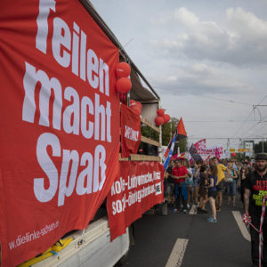Ein Banner mit der Aufschrift "Teilen macht Spaß", befestigt an einem Demo-Lauti
